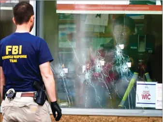  ?? AP ?? BLOODBATH: Investigat­ors work the scene of a shooting at a supermarke­t in Buffalo, N.Y., Monday.