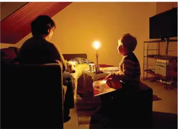  ?? FOTO: JULIAN STRATENSCH­ULTE/DPA ?? Eine brennende Kerze erleuchtet den Raum einer Familie, der der Strom abgestellt wurde. Damit das nicht passiert, setzt das Saarland auf eine Kooperatio­n zwischen säumigen Kunden, Jobcenter und Stromanbie­ter.