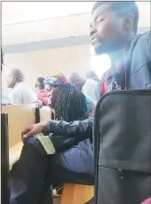  ?? (Pics: Sibusiso Shange) ?? Theuri Sammy busy on his cellphone after his conviction. (R) Doris Mndzebele (with dreadlocks) seated with those who appeared in court charged with drink-driving at the Mbabane Magistrate­s Court.