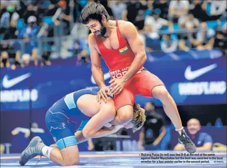  ?? HT PHOTO ?? Bajrang Punia (in red) was tied 9-9 at the end of the semis against Daulet Niyazbekov but the bout was awarded to the local wrestler for a four pointer earlier in the second period.