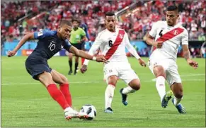  ??  ?? Kylian Mbappé van Frankrijk doet alles om de twee spelers van Peru van zich af te schudden. (Foto: FIFA)