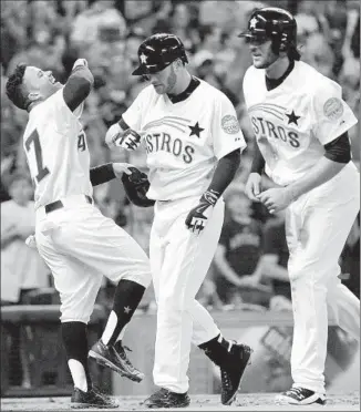  ?? Eric Christian Smith
Associated Press ?? ROBBIE GROSSMAN, center, celebrates his three-run home run with Jose Altuve, left, and Jake Marisnick in the seventh inning against the Angels, who managed two hits in a 4-0 loss at Houston.