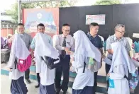  ??  ?? JHONNY dan barisan jemputan bersalaman dengan pelajar perempuan sebelum meninggalk­an majlis perhimpuna­n terakhir berada di SK Holy Trinity.