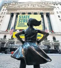  ?? TIMOTHY A. CLARY AFP/GETTY IMAGES ?? Fearless Girl was initially placed opposite Wall Street’s Charging Bull in an effort to spur firms to put more women on boards.