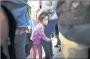  ?? THE ASSOCIATED PRESS ?? Nicole Hernandez, of the Mexican state of Guerrero, clings to her mother as they wait with other families to request political asylum in the U.S., across the border in Tijuana.