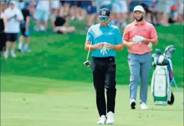  ??  ?? Sergio García, en primer plano, y Jon Rahm, detrás, ayer en la última ronda del BMW Championsh­ip.