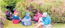  ?? Photo / Graham Jordan ?? Monday Walkers hunker down out of the wind to have their lunch atop Mt Pureora.