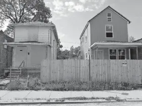  ?? [KYLE ROBERTSON/DISPATCH] ?? A house being remodeled sits next to a house that is boarded up on Sullivant Avenue in Columbus.