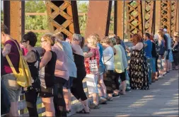  ?? CP PHOTO STEPHEN MACGILLIVR­AY ?? Mourners join hands Monday on the Bill Thorpe Walking Bridge in downtown Fredericto­n as thousands did so to remember last week’s shooting victims.