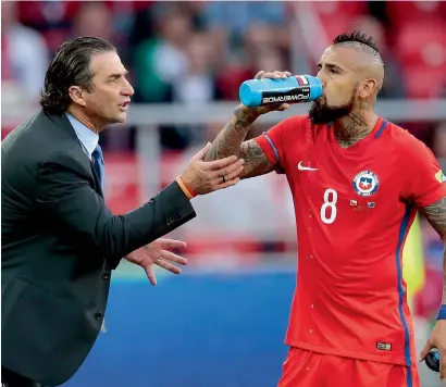  ?? — AP ?? Chile coach Juan Antonio Pizzi talks with Arturo Vidal during the Confederat­ions Cup match against Australia.