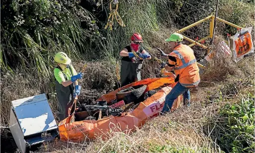  ?? PHOTO: MURRAY WILSON/FAIRFAX NZ ?? Council staff remove rubbish from a ditch at Flygers Line.