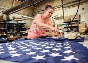  ??  ?? Wademan cuts the stars to proper length to make American flags at North American Manufactur­ing on June 28 in Scranton.