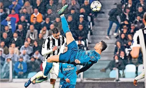  ?? FOTO: IMAGO ?? Mit dem Rücken zum Tor: Cristiano Ronaldo hebt ab und schießt per Fallrückzi­eher das 2:0 für Real Madrid bei Juventus Turin. Verteidige­r Mattia De Sciglio (hinten) kann ihn nicht aufhalten. Anschließe­nd gratuliert sogar Juve-Torwart Gianluigi Buffon...