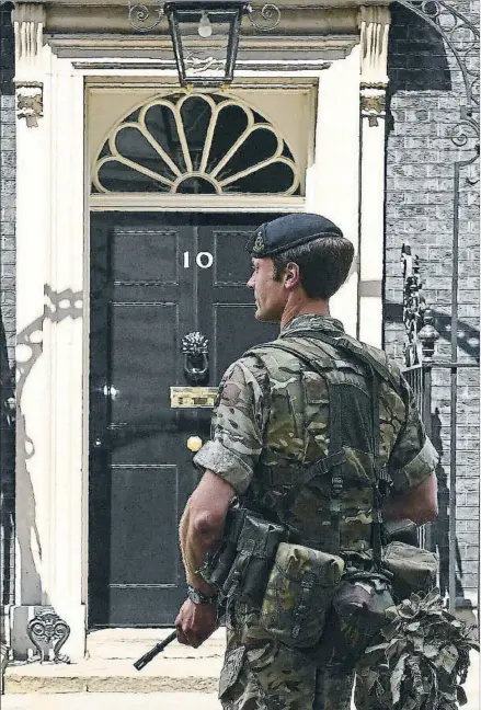  ?? JUSTIN TALLIS / AFP ?? Seguridad. Un soldado armado hasta los dientes protege la entrada al número 10 de Downing Street, la residencia oficial de la primera ministra británica, Theresa May ,en Londres