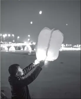  ?? Photo: VCG ?? A resident of Binzhou, East China’s Shandong Province is one of many on Monday who launched a Kongming Lantern, a Chinese traditiona­l lantern that uses hot air to fly hundreds of meters into the sky. The lanterns are sent to the heaven as a blessing for the Lunar New Year.