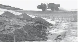  ?? STEPHEN M. DOWELL/ORLANDO SENTINEL ?? Resembling a desert landscape, a large truck climbs a mountain of coal ash at OUC’s coal-burning facility, Stanton Energy Center in Orlando.