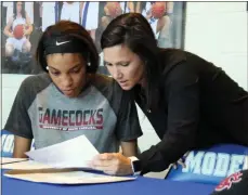  ?? Jeremy Stewart / RN-T ?? Model senior Victaria Saxton (left) goes over her letter of intent to play for South Carolina from Lady Devil head coach Sally Echols.