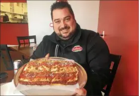  ?? DAVID S. GLASIER — THE NEWS-HERALD ?? Master Pizza owner Michael LaMarca holds a freshly baked Detroit Red Top pizza at the franchise’s recently opened Eastlake store.