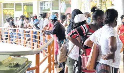  ?? FILE ?? In this May 2020 photo, a long line of people waiting to collect their CARE grant is seen at Pavilion Mall in Half-Way Tree. A CAPRI study says CARE, the highly politicall­y touted excuse for COVID-19 welfare, has not reached a large proportion of those for whom it was intended.