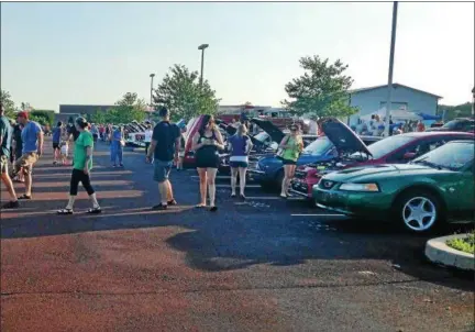  ?? BOB KEELER — DIGITAL FIRST MEDIA ?? Spectators check out some of the cars in the new by the Moonlite car show held July 28 at Pennridge High School.