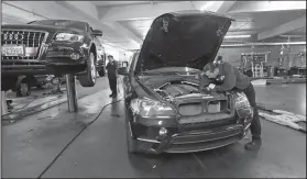  ?? Elaine Thompson/AP ?? Technician: In this Wednesday, April 25 photo, auto technician Anthony Sterns, right, works to replace the coolant expansion tank on a 2011 BMW at the Fat City German Car service shop in Seattle. At first, dumping your old car might seem like a...