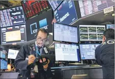  ?? CRAIG RUTTLE — THE ASSOCIATED PRESS FILE ?? In this March 16, 2020 file photo, trader Gregory Rowe works on the floor of the New York Stock Exchange at the end of the trading day. Stocks are drifting between small gains and losses in early trading on Wall Street, Tuesday, Oct. 6, 2020, a day after a broad rally.