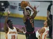  ?? TONY DEJAK — THE ASSOCIATED PRESS ?? Collin Sexton shoots as the Hawks’ Tony Snell (19) and Trae Young defend Feb. 23 at Rocket Mortgage FieldHouse.