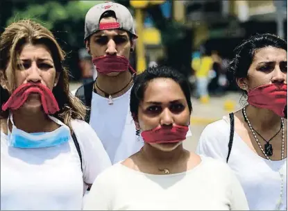 ?? RONALDO SCHEMIDT / AFP ?? Participan­tes en una de las marchas silenciosa­s de ayer en Caracas, luciendo la boca tapada