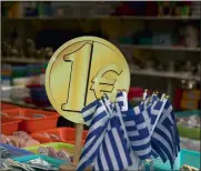  ?? PHOTO: REUTERS ?? Greek flags are displayed for sale for one euro at a shop in central Athens yesterday. Greek banks are set to keep broad cash controls in place for months.