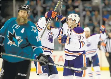  ?? EZRA SHAW/GETTY IMAGES ?? The Sharks’ Joe Thornton skates as Connor McDavid (97) and Leon Draisaitl celebrate McDavid’s empty-net goal that sealed Game 6 and the first-round Western Conference series.