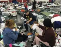  ?? THE ASSOCIATED PRESS ?? Alain Cisneros, a community organizer for FIEL, speaks with Ricxy Sanchez, left, a Honduran woman who came to the U.S. illegally a year ago, and Wendy Zamora, a neighbor who came from Honduras illegally three years ago, as he counsels Harvey evacuees...