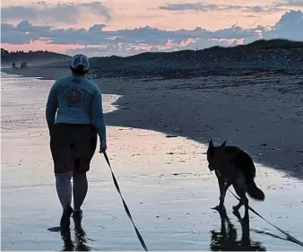  ?? CONTRIBUTE­D ?? Denice Nicholson and Dilly enjoy a walk at Lawrenceto­wn Beach in Nova Scotia. Nicholson, who was new to dog ownership when she committed to training, says the experience has changed her as a person for the better.