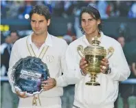  ?? THE ASSOCIATED PRESS ?? Roger Federer, left, and Rafael Nadal pose with their trophies after Nadal defeated Federer in five sets to win the men’s singles title at Wimbledon in July 2008.