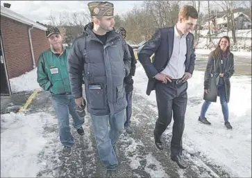  ?? Jeff Swensen Getty Images ?? CONOR LAMB, second from right, is a Democrat running for Congress in a Pennsylvan­ia district that Donald Trump won by 20 points. The former federal prosecutor and Marine veteran is gaining in the polls.