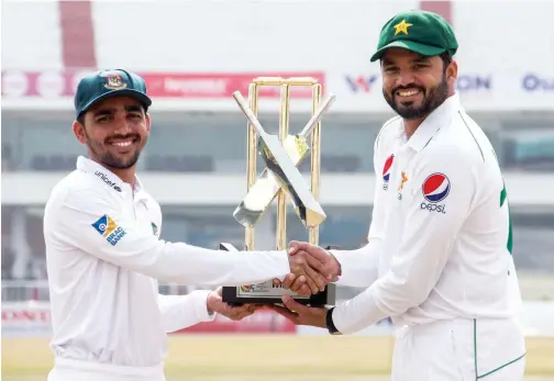  ?? Reuters ?? ↑
Bangladesh’s Mominul Haque and Pakistan’s Azhar Ali pose with the trophy, during the unveiling ceremony on Thursday.