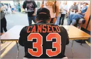  ?? RAY CHAVEZ — STAFF ARCHIVES ?? Pittsburg Diamonds designated hitter Jose Canseco signs memorabili­a during a game against the Vallejo Admirals at Winter Chevrolet Stadium in Pittsburg on June 23.