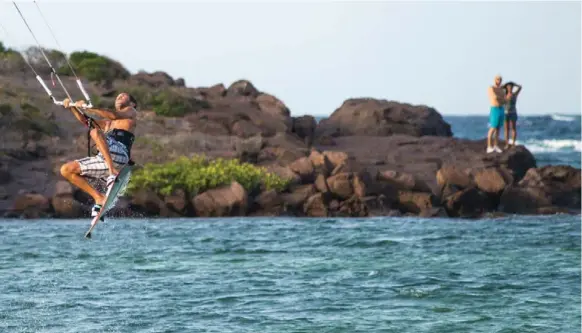  ?? ALAN BEHR PHOTOS/TRIBUNE NEWS SERVICE ?? A kitesurfer goes airborne in Grand Cul de Sac, one of the many bays that crenellate the eight-square-mile island.