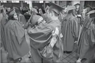  ?? SARAH GORDON/THE DAY ?? Bountai McCaffrey, left, hugs friend Kevin Fay before the Saint Bernard School commenceme­nt Friday at the Cathedral of Saint Patrick in Norwich.