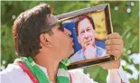  ?? -- AFP ?? PESHAWAR: A supporter of Pakistan Tehreek-e-Insaf (PTI) party kisses a photo frame of former Prime Minister Imran Khan, takes part in a protest rally for the release of leader Imran Khan, in Peshawar on March 31, 2024.