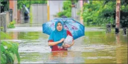  ??  ?? A woman wades through a flooded neighbourh­ood following three days of heavy rain in Banda Aceh, Indonesia, on Saturday.
AFP