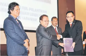  ??  ?? Entulu (third right) presents an appointmen­t certificat­e to one of the licensing agencies, as Mazlan (second right) and Mussen (left) look on.