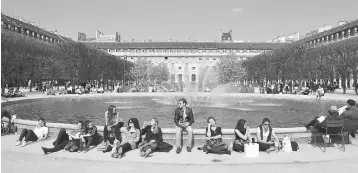  ??  ?? People enjoy the sun and warm spring temperatur­es in the garden of the Palais-Royal, in the center of the French capital Paris. The leader of the National Front (FN) blames the euro for driving up prices, hurting exports and adding to France’s already colossal trade deficit. — AFP photo