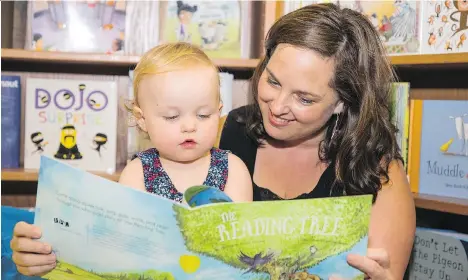  ?? FRANCIS GEORGIAN ?? Kim Page shares The Reading Tree with her 19-month-old daughter Madison during a Raise-a-Reader literacy program at the Vancouver Public Library’s central branch last week. Written by librarians, the book is part children’s story, part parents’ guide...