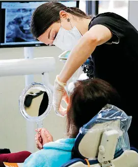  ?? [PHOTO BY PAUL HELLSTERN, THE OKLAHOMAN] ?? A patient receives dental work at the Straka Terrace clinic this week in Oklahoma City.