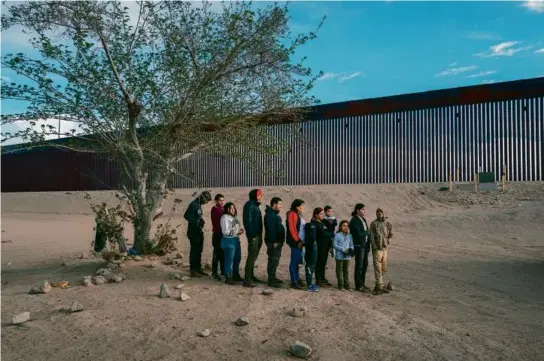  ?? BRANDON BELL/GETTY IMAGES ?? A group of migrants waited to be processed after crossing the Rio Grande on April 2 in El Paso, Texas.