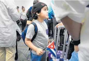  ?? CARLINE JEAN/STAFF PHOTOGRAPH­ER ?? Juan Diego Fuste, 6, of Boston, waits with his parents to board a Jet Blue flight to Havana from Fort Lauderdale.