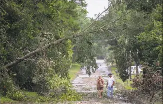  ?? Jason Lee / Associated Press ?? Jack and Linda Hodgkiss look at a tree that fell across Bayshore Drive in Little River, S.C., possibly caused by one of the tornados that passed through the area as Hurricane Dorian approached South Carolina on Thursday.