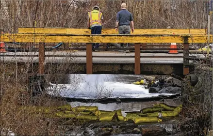  ?? PHOTOS BY GENE J. PUSKAR/ASSOCIATED PRESS ?? HEPACO workers, an environmen­tal and emergency services company, observe a stream Feb. 9 in East Palestine, Ohio, as the cleanup continues after the Feb. 3 derailment of a Norfolk Southern freight train.