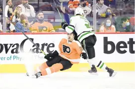  ?? DERIK HAMILTON/AP ?? The Flyers’ James van Riemsdyk, left, falls to the ice as he is hit by the Dallas Stars’ Jani Hakanpaa on Monday in Philadelph­ia.