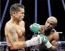  ?? John Locher / Associated Press ?? Floyd Mayweather (right) throws a straight right en route to winning a unanimous decision over Marcos Maidana.